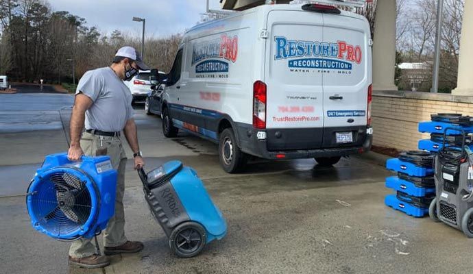 Restore Pro technician water damage equipment with service van